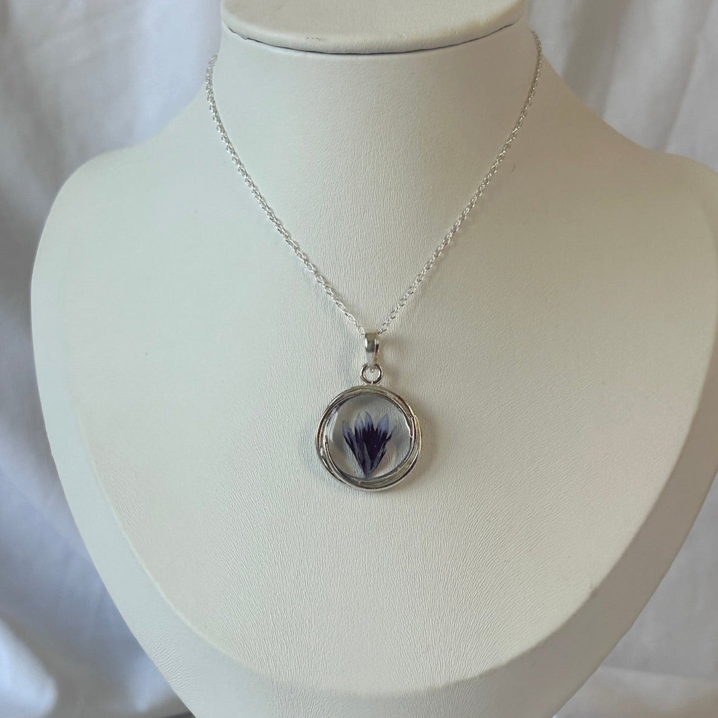 Necklace with a pendant on a white mannequin bust against a white background