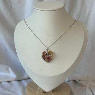 Necklace with a heart-shaped pendant on a mannequin bust against a white background