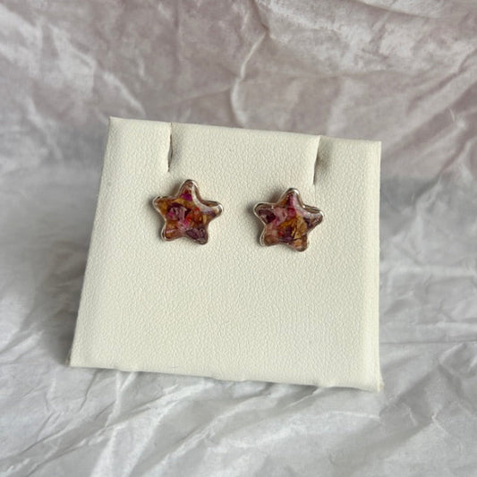 Star-shaped earrings on a white card with a textured gray background