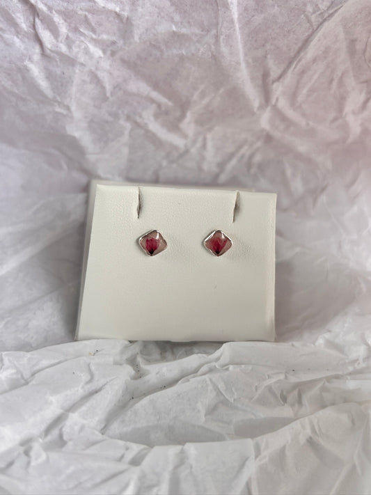 Pair of earrings in a white box on a textured white surface