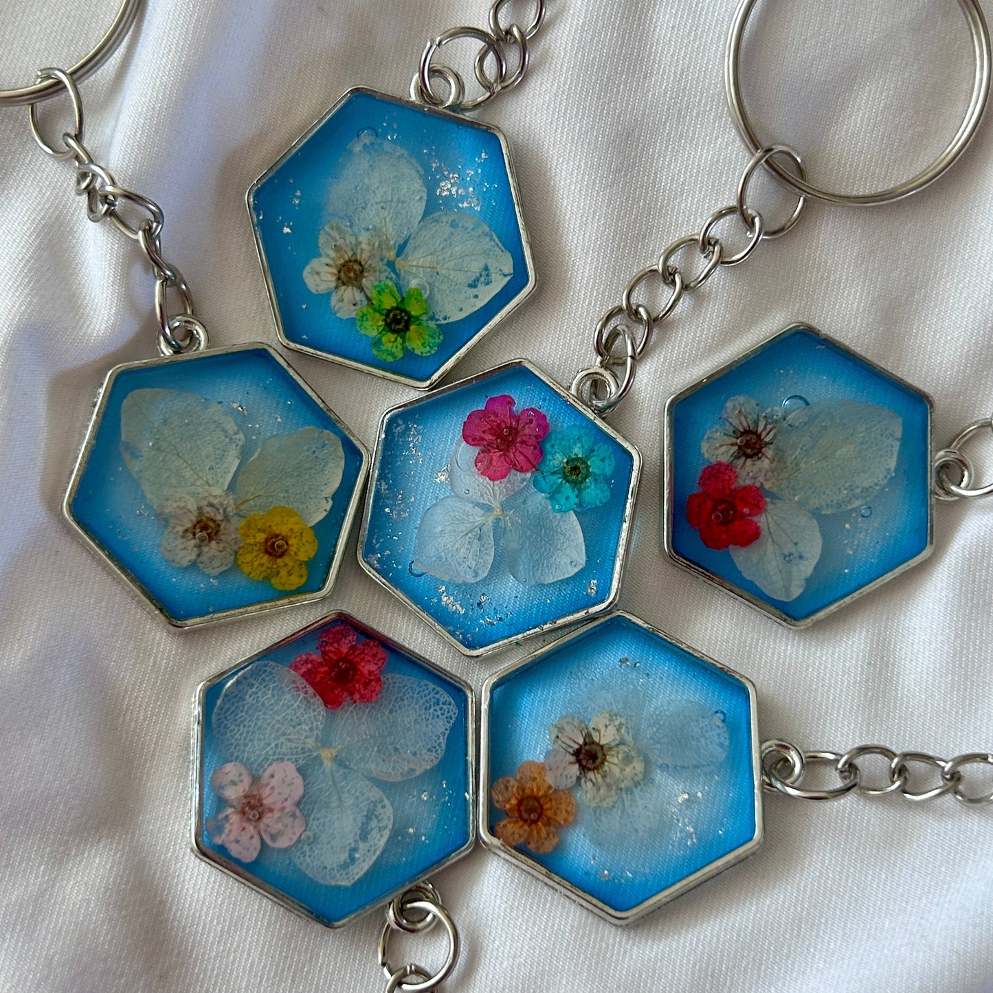 Hexagonal keychain with floral designs on a white background